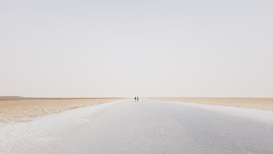 two person walling on desert